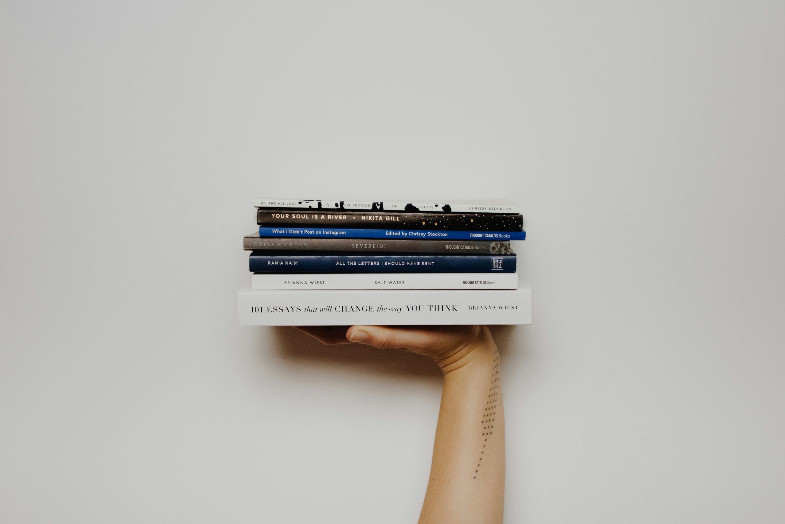 Hand in the air lifting books on a white background.