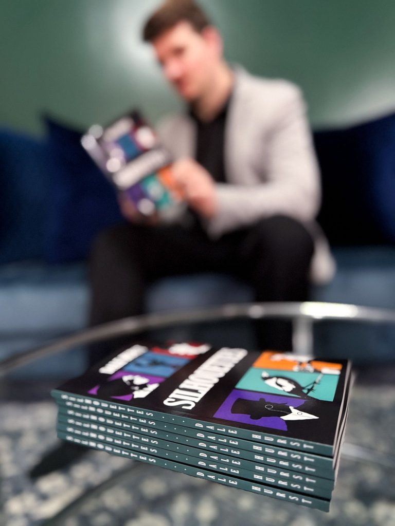 A stack of six books with the title SILHOUETTES in the centre of the front cover and down the spine, sitting on a glass coffee table.